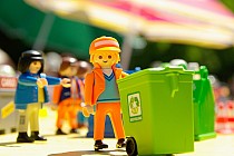 Zdjęcie przedstawia ludzika z klocków z pojemnikiem na odpady