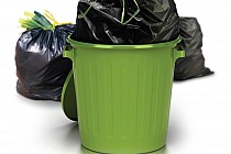 Zdjęcie przedstawia zielony kubeł na odpady.