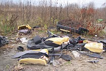 Zdjęcie przedstawia odpady zalegające na niezabudowanej działce prywatnej